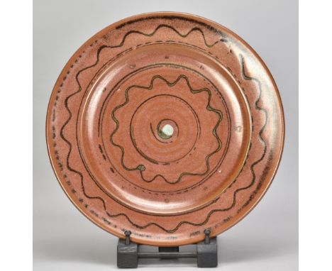 RAY FINCH (1914-2012) for Winchcombe Pottery; a stoneware charger covered in iron rich glaze with trailed decoration, impress