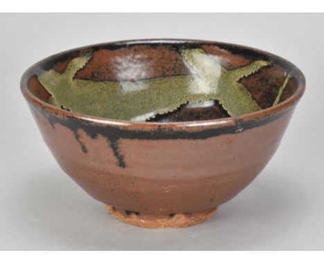 JIM MALONE (born 1946); a stoneware bowl covered in tenmoku breaking to kaki glaze with copper green pours, impressed JM and 