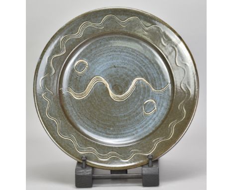 RAY FINCH (1914-2012) for Winchcombe Pottery; a stoneware charger covered in blue/grey glaze with incised meander decoration,