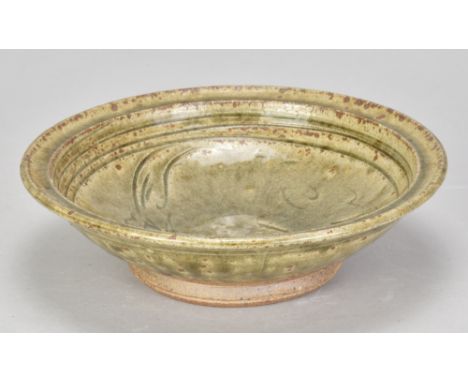 JIM MALONE (born 1946); a stoneware dish covered in green ash glaze with incised fish decoration, impressed JM mark, diameter