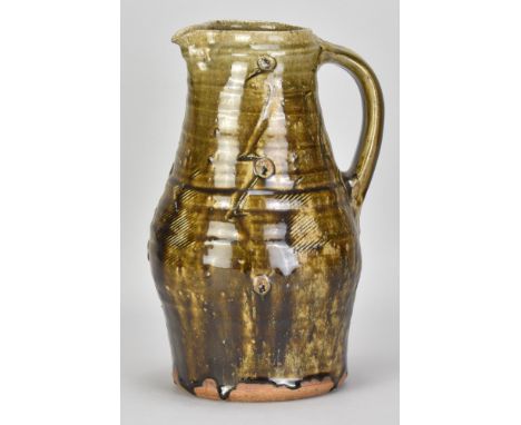 JIM MALONE (born 1946); a large stoneware pitcher covered in dark green ash glaze with incised and applied decoration, incise