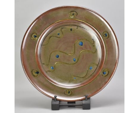 RAY FINCH (1914-2012) for Winchcombe Pottery; a stoneware charger covered in iron rich glaze with trailed meander decoration 