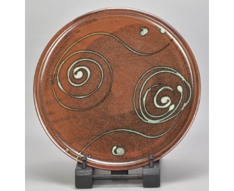 RAY FINCH (1914-2012) for Winchcombe Pottery; a stoneware platter covered in iron rich glaze with trailed scroll decoration, 