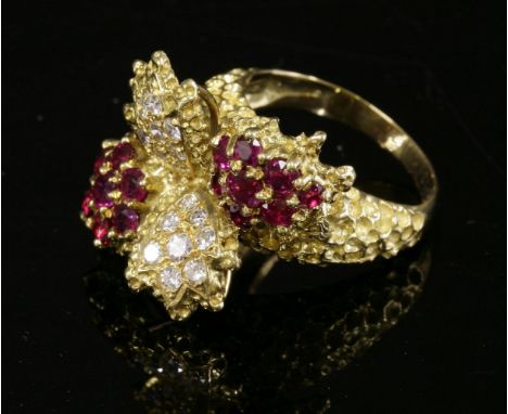 An 18ct gold ruby and diamond spray style ring, c.1970,with a splash effect head.  Two clusters of claw set circular mixed cu