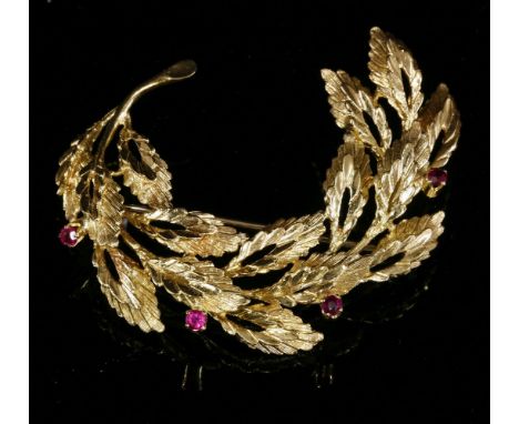 A Continental 18ct gold synthetic ruby spray brooch, c.1960,composed of a curved and arched leaf bough.  Incised texture and 