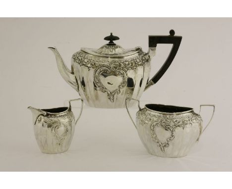 A Victorian three-piece silver tea service,James Dixon, Sheffield, 1900,the fluted bodies with a vacant rocaille cartouche, a