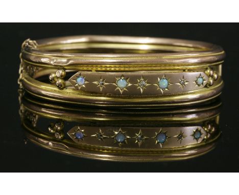 An Edwardian gold, opal and diamond set hinged bangle,with two parallel frames.  Ridged and milled decoration with an applied