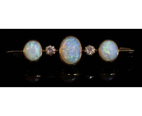 An Edwardian five stone opal and diamond bar brooch,with three oval cabochon opals, all individually rub set to a blade edge 