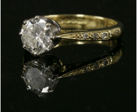 An 18ct gold single stone diamond ring,with diamond set shoulders.  A brilliant cut diamond, estimated as approximately 1.03c