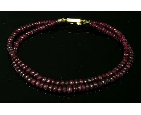 A two-row graduated ruby bead bracelet,with bouton ruby beads, 2.5 to 4.8mm in size, strung plain to an 18ct gold, two-row bo