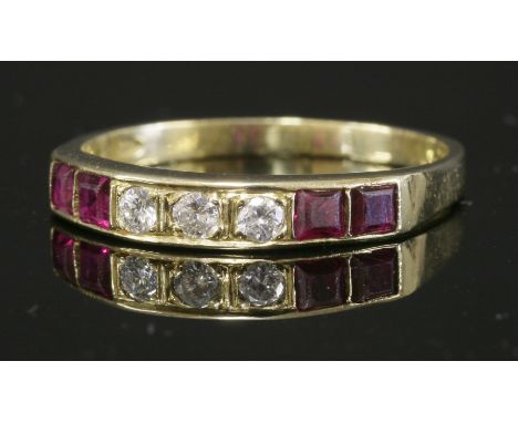 An 18ct gold, diamond and ruby half eternity ring,with a row of three brilliant cut diamonds, grain set to the centre in box 