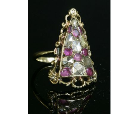 A ruby and diamond cluster ring,composed of a triangular, arched plaque, pavé set with graduated rose cut diamonds and oval m