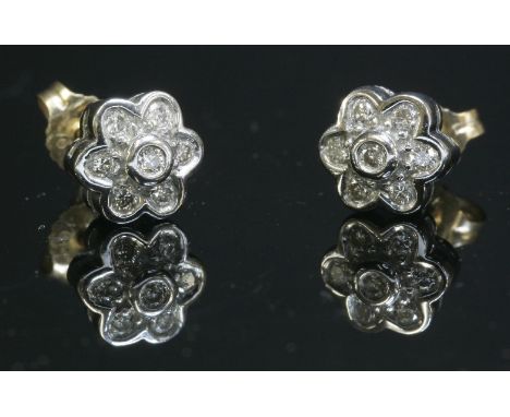 A pair of 9ct gold diamond set cluster earrings,with brilliant cut diamonds, grain and rub set to a white head, with post and