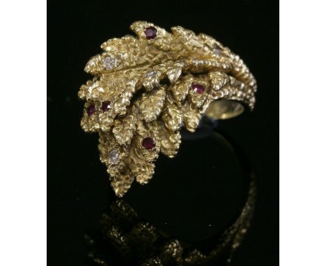 A 9ct gold ruby and diamond leaf spray ring,with eight cut diamonds and Swiss cut rubies, grain set and scattered across the 