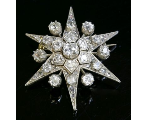 A late Victorian, diamond set, India star brooch/pendant,with a cushion cut diamond, set at the centre in a cut down collet. 