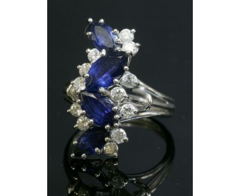 An 18ct white gold, sapphire and diamond fingerline cluster ring, c.1970,by P J Watson.  A central row of four marquise cut s