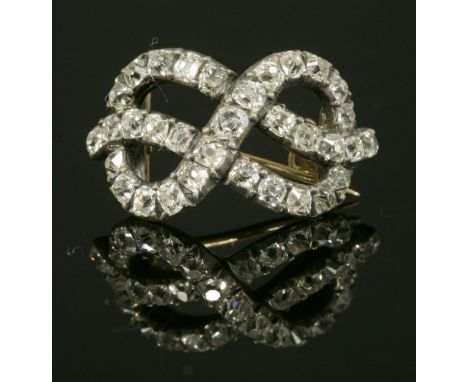 A Georgian, diamond set, figure of eight knot brooch,of slightly arched from, with a line of cushion-shaped old Swiss cut dia