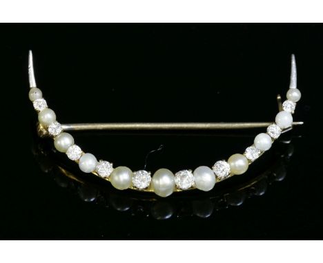 A diamond and seed pearl open crescent brooch, c.1905,possibly American.  A line of graduated seed pearls, all peg set altern