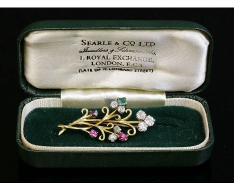 A two-colour gold, diamond, ruby and emerald spray brooch, c.1945-1955,a scrolling wire spray with a trefoil cluster of old E