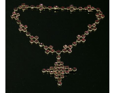 A Georgian gold, flat cut, garnet rivière, c.1800,with a matching garnet cross pendant.  The rivière composed of open quatref