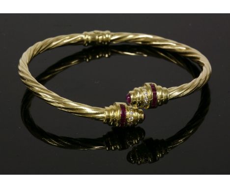An Italian ruby and cubic zirconia hinged crossover bangle,of twisted rope form.  Crossover terminals, each with a central ba