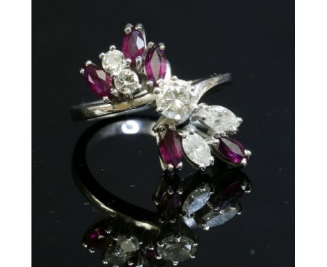 A white gold, diamond and ruby spray ring, c.1970,with a brilliant cut diamond, six claw set to the centre in a plain collet.