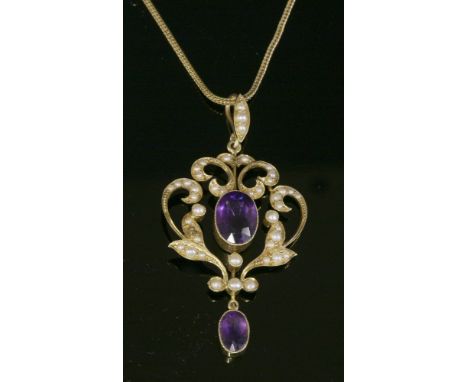 An Edwardian gold, amethyst and split pearl scrolling cartouche-shaped Art Nouveau pendant,an oval mixed cut amethyst, millig