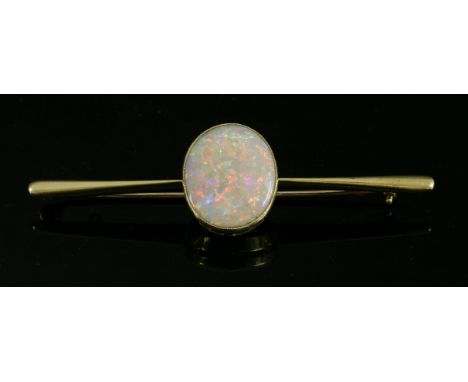 A single stone opal gold bar brooch, c.1920,with an oval cabochon opal, milligrain set in a plain collet, at the centre of a 