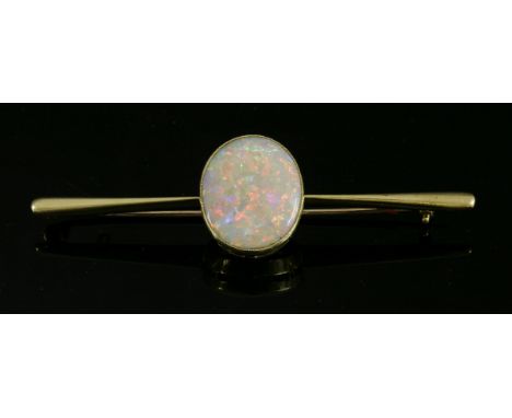 A single stone opal gold bar brooch, c.1920,with an oval cabochon opal, milligrain set in a plain collet, at the centre of a 