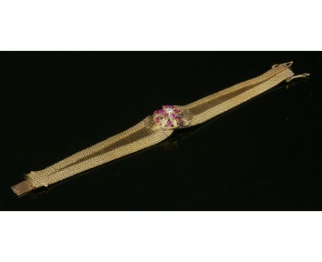 A Continental gold, diamond and ruby bracelet, c.1950,with a central boss composed of an old European cut diamond, claw set t