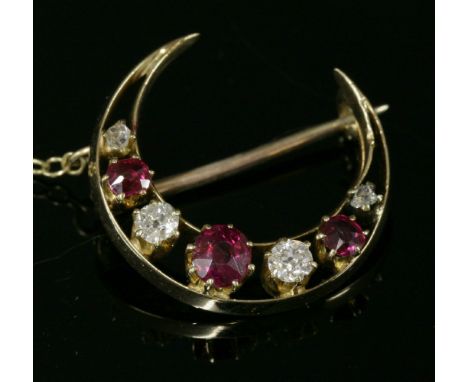 A late Victorian seven stone ruby and diamond closed crescent brooch,with a blade edge bar frame.  Graduated circular mixed c