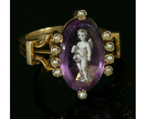 An Edwardian paste and split pearl ring,with an oval purple paste, with hand painted enamel putto, claw set with split pearl 