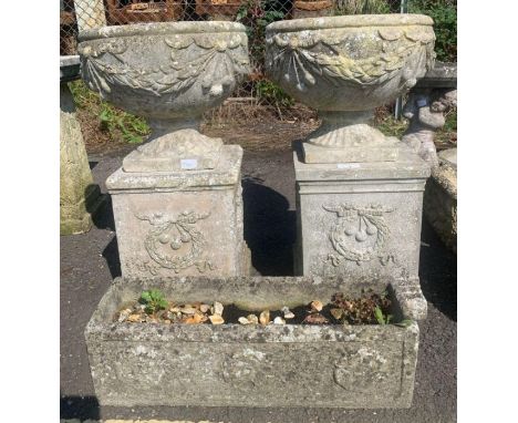 Pair of reconstituted stone urn planters on plinths along with a trough planter