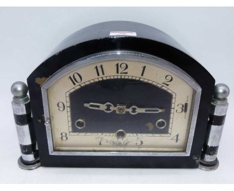An Art Deco mantel clock, having ebonised and chrome mounted case, the arched dial with Arabic numerals, chiming and silent m