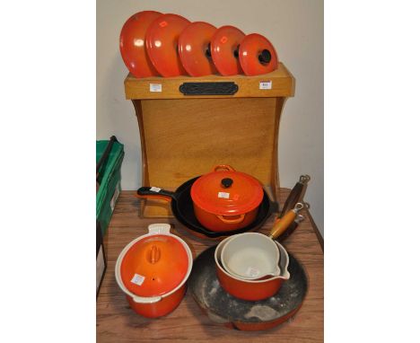 A collection of Le Creuset orange enamel cast iron pans