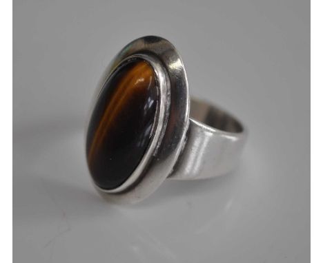 A Danish Sterling silver dress ring, set with a cabochon cut tiger's eye, marked NE Froms 925 S for Niels Erik, size H, toget