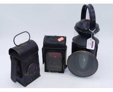 A 20th century black painted hand-held railway lantern, marked BR (E), h.30cm; together with two other signal lanterns (3)