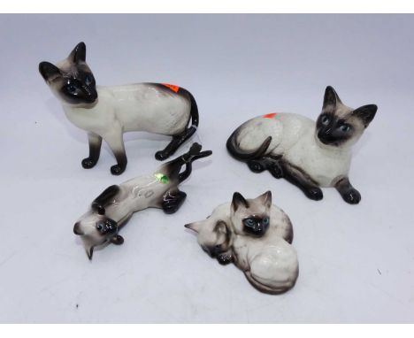 A Beswick figure of a Persian cat, seated looking up, model No.1867; together with a Beswick Siamese cat standing, model No.1