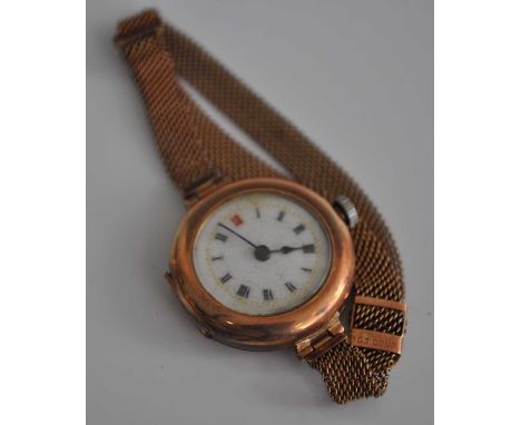 A vintage ladies 9ct gold cased wrist watch having manual wind movement, unsigned white enamel dial and on 9ct gold mesh link