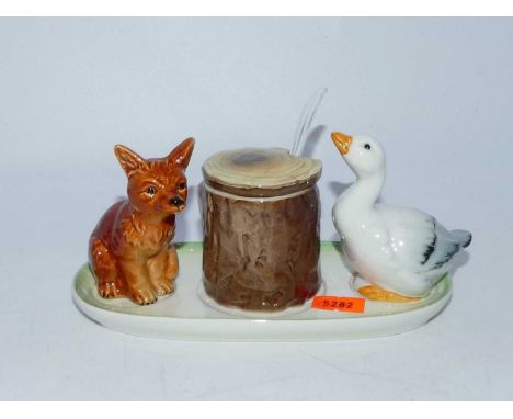 A mid-20th century Goebel novelty cruet, the central mustard in the form of a treetrunk flanked by a duck and dog 