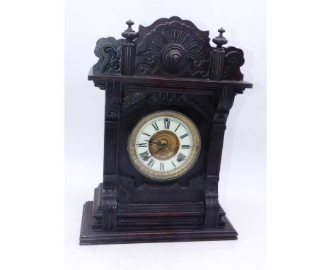 A late 19th century American walnut cased mantel clock, having an enamelled chapter ring with Roman numerals, eight-day movem
