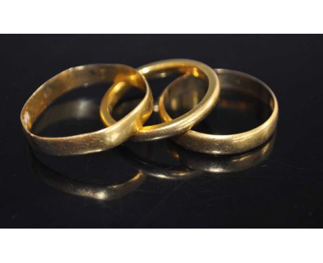 A 22ct gold wedding band, size K/L, together with two others, gross weight 7.6g (3)