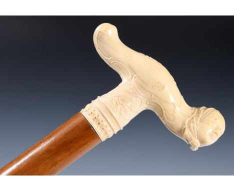 A 19th century walking stick, with carved ivory tau shaped handle, in the style of a Meissen veiled lady, 