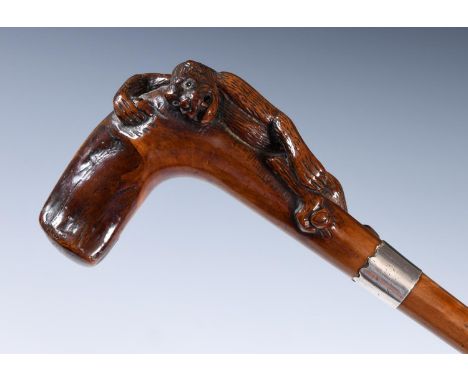 A 19th century fruitwood walking stick, with carved handle, in the form of a gorilla, with glass eyes, with silver mount, 90 