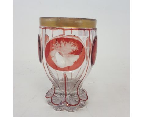 A late 19th century Bohemian clear and ruby flash glass beaker, decorated flowers, an anchor and torches, with a gilt border,