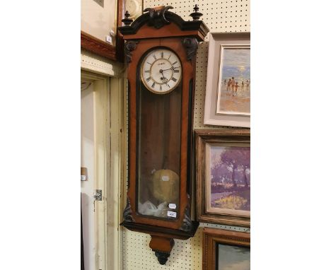 A Vienna regulator style clock, the 16 cm diameter enamel dial with Roman numerals, in a walnut and ebonised case, lacks fini