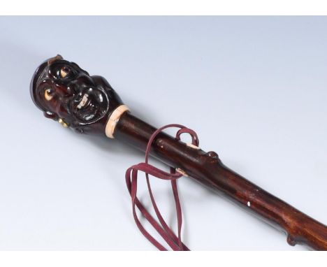 A 19th century walking stick, with carved handle, in the form of a head of a sailor with glass eyes, bone teeth and decoratio