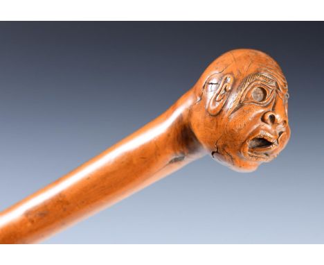 A 19th century folk art walking stick, with carved handle, in the form of a grotesque head, 90 cm 