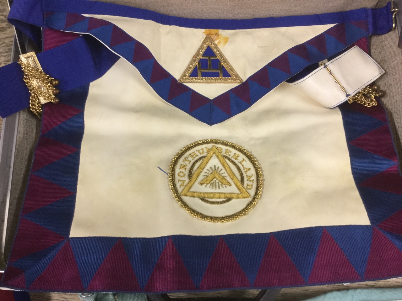 A briefcase containing a quantity of masonic gear leather aprons