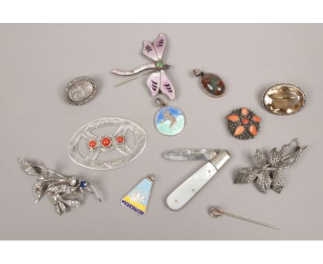 A box of vintage silver brooches including marcasite set examples, silver and mother of pearl fruit knife, enamelled dragonfl